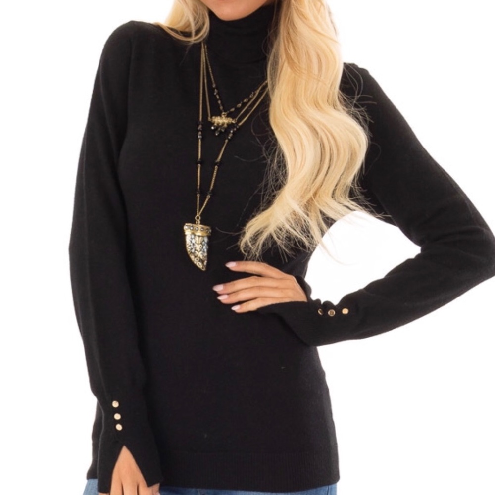Black turtleneck top with gold cuff links